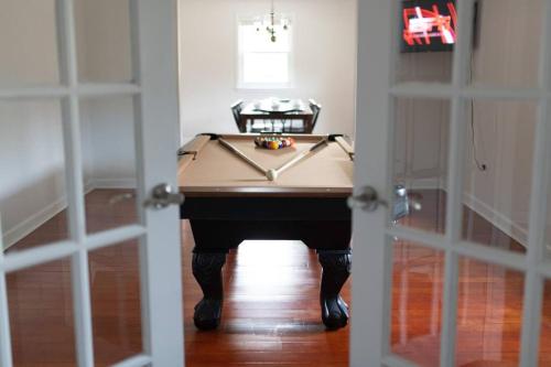 a pool table sitting in a room with a door at Relaxing 5-Bedroom Villa with Outdoor Oasis in Bay Saint Louis