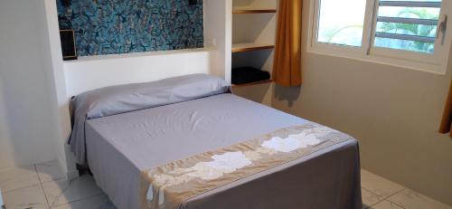 a small bedroom with two beds and a window at Fare Onavai in Punaauia