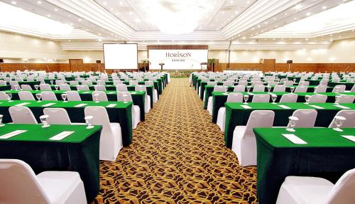 a conference hall with green and white chairs at Horison Ultima Bandung in Bandung