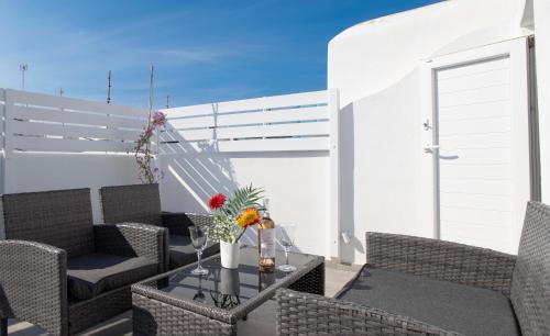 a patio with chairs and a table with flowers on it at The Mykonos Bougainvillea Townhouse in Mýkonos City