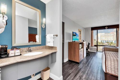 y baño con lavabo y espejo. en Best Western Orlando Gateway Hotel en Orlando