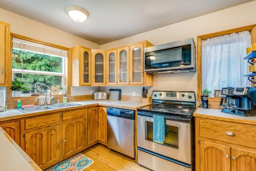 a kitchen with wooden cabinets and a stove top oven at Port Susan Bay - A in Sunny Shore Acres