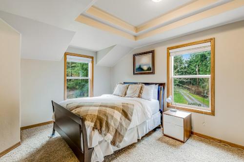 a bedroom with a bed and two windows at Port Susan Bay - A in Sunny Shore Acres