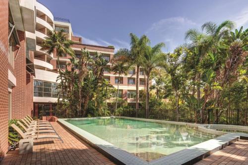 a swimming pool in front of a building at Adina Apartment Hotel Sydney Surry Hills in Sydney