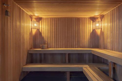 a sauna with a wooden bench and lights in it at Adina Apartment Hotel Wollongong in Wollongong
