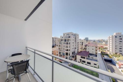 a balcony with a chair and a view of a city at Adina Apartment Hotel Wollongong in Wollongong