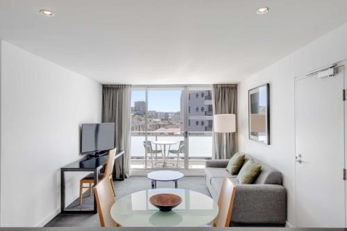 a living room with a couch and a table at Adina Apartment Hotel Wollongong in Wollongong