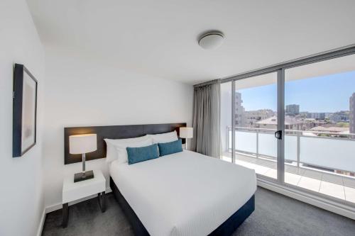 a bedroom with a bed and a large window at Adina Apartment Hotel Wollongong in Wollongong