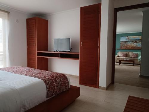 a bedroom with a bed and a tv in it at Hotel Boutique Confort Suites in Popayan