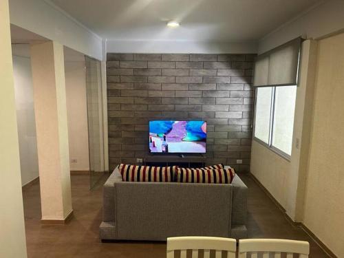 a living room with a couch and a tv at Departamento zona céntrica MDZ in Mendoza