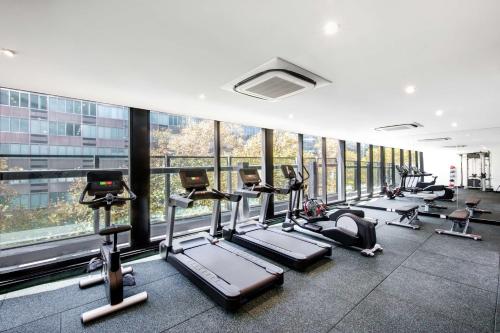 a gym with a bunch of treadmills and machines at Vibe Hotel North Sydney in Sydney