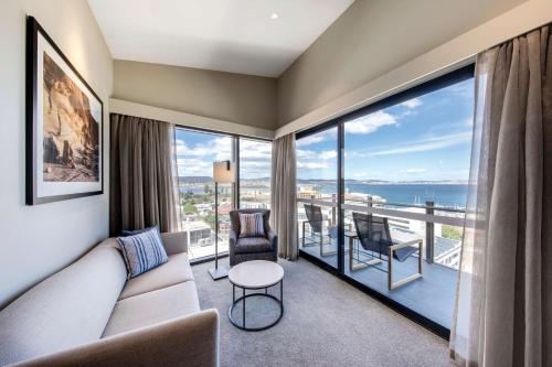 a living room with a couch and a view of the ocean at Vibe Hotel Hobart in Hobart