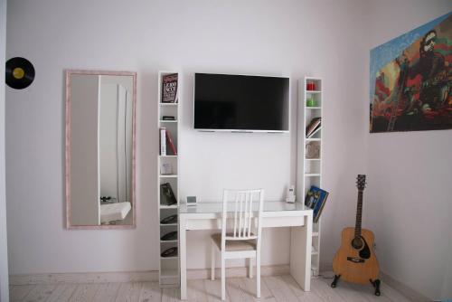 a white desk with a mirror and a television on a wall at Big Johnny B in Rome