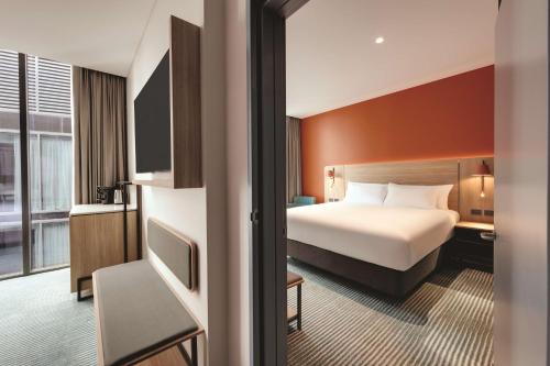 a hotel room with a bed and a tv at Travelodge Hotel Hurstville Sydney in Sydney