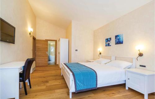 een slaapkamer met een groot wit bed en een bureau bij Lovely Home In Turcic With Kitchen in Vantačići