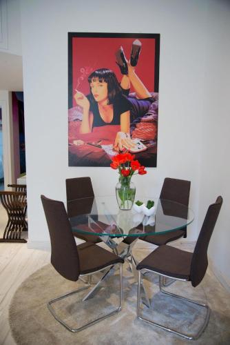 a glass table with chairs and a painting on the wall at Big Johnny B in Rome
