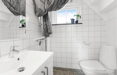 łazienka z toaletą, umywalką i oknem w obiekcie 2 Bedroom Beautiful Apartment In Gudhjem w mieście Gudhjem