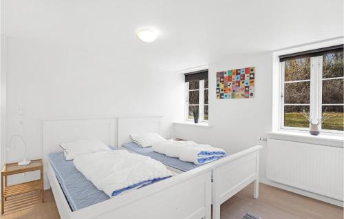 biała sypialnia z łóżkiem i 2 oknami w obiekcie 2 Bedroom Beautiful Apartment In Gudhjem w mieście Gudhjem
