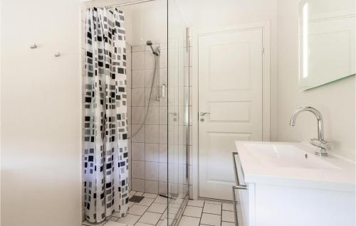 uma casa de banho branca com um chuveiro e um lavatório. em Lovely Home In Slagelse With House Sea View em Slagelse