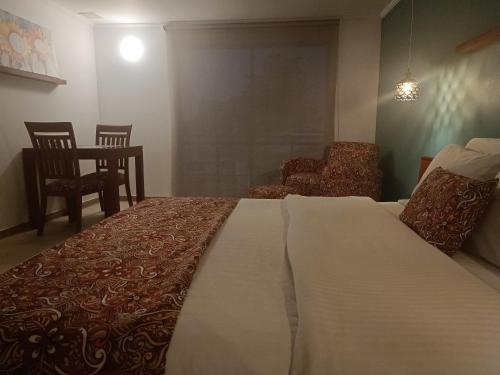 a bedroom with a large bed and a chair at Hotel Boutique Confort Suites in Popayan