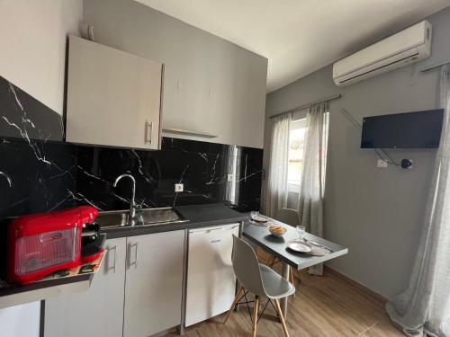 a kitchen with white cabinets and a table with chairs at SPN.SPIROS APARTMENTS PREVEZA in Preveza