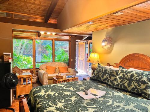 a bedroom with a bed and a couch at Maui What a Wonderful World Bed & Breakfast in Wailea