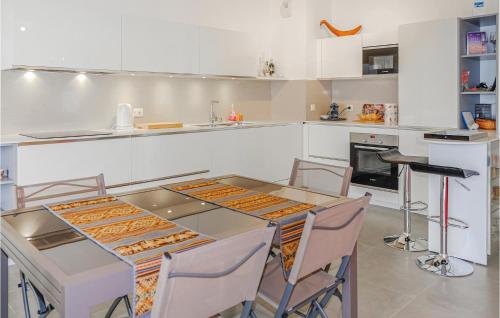 une cuisine avec une table, des chaises et un comptoir dans l'établissement Gorgeous Apartment In Ajaccio, à Ajaccio