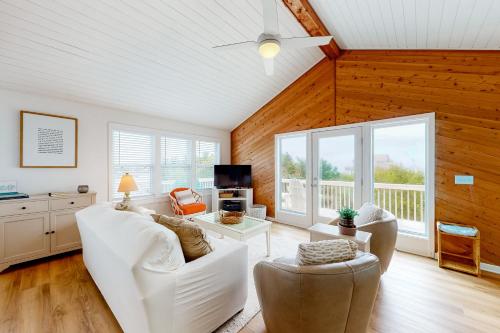 a living room with white furniture and wooden walls at Horizon House 405 in Frisco