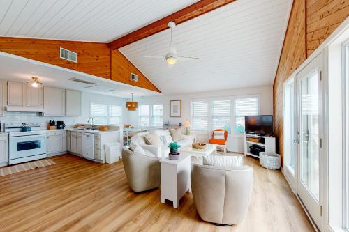 a living room with white furniture and a kitchen at Horizon House 405 in Frisco