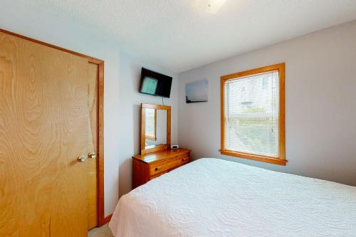 a bedroom with a bed and a dresser and a window at Horizon House 405 in Frisco