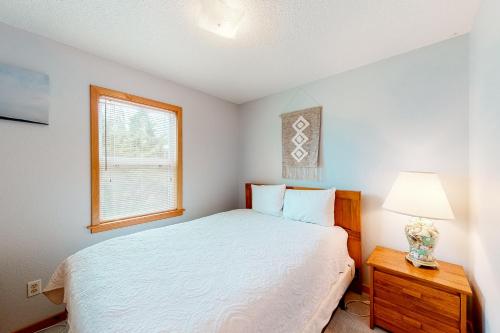 a bedroom with a bed and a lamp and a window at Horizon House 405 in Frisco