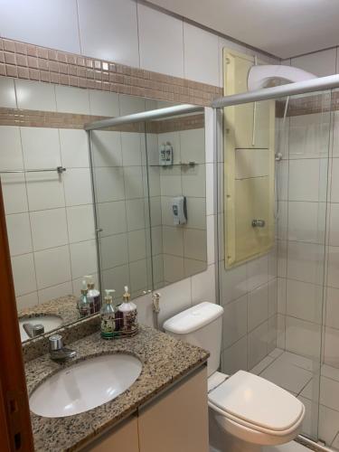 a bathroom with a toilet and a sink and a shower at Flat Romântico à Beira Lago M 401 in Brasilia