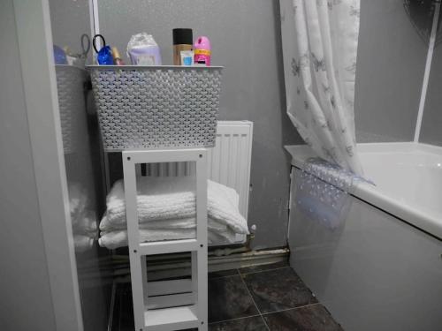 a bathroom with a towel shelf next to a bath tub at Adorable 2 bed house ideal for Family of Four in Manchester