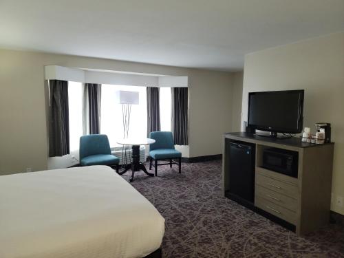 a hotel room with a bed and a flat screen tv at Grand Legacy At The Park in Anaheim
