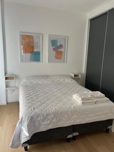uma cama num quarto com duas fotografias na parede em Departamento Villa Mercedes San Luis FUCO 3 em Villa Mercedes