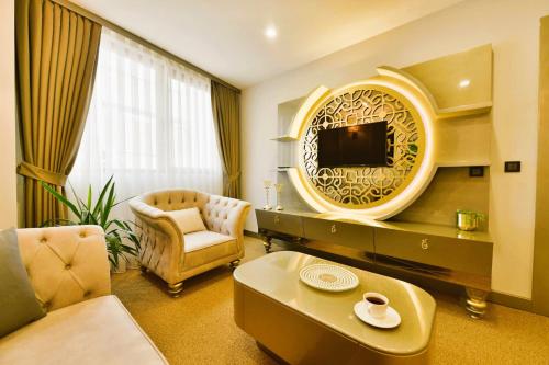 sala de estar con TV, sofá y silla en Ghan Hotel, en Estambul