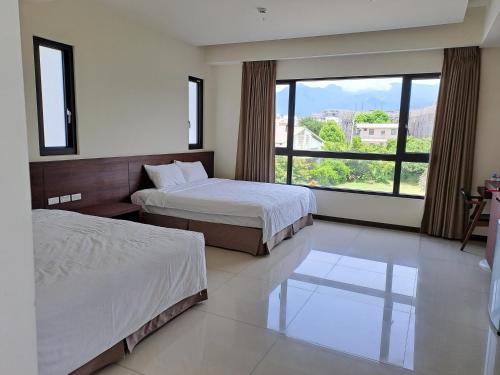 ein Hotelzimmer mit 2 Betten und einem großen Fenster in der Unterkunft Really good home in Taitung