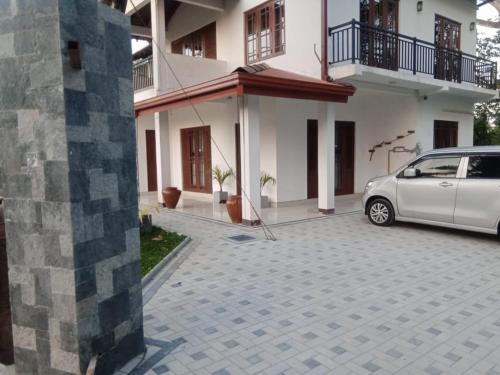 a white car parked in front of a house at White House Family Stay in Maspota