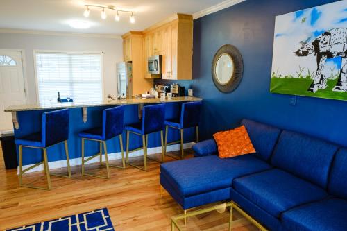 a living room with a blue couch and a bar at Amazing ATL downtown houses - minutes walk to bars, food and transport! in Atlanta