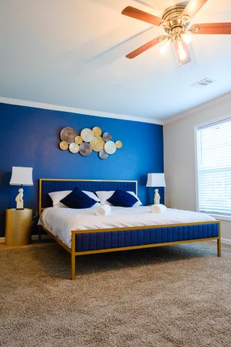 a blue bedroom with a bed and a ceiling fan at Amazing ATL downtown houses - minutes walk to bars, food and transport! in Atlanta