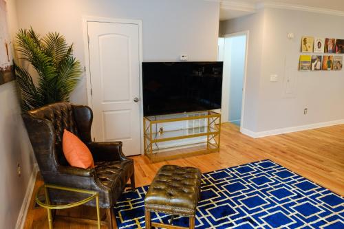 a living room with a chair and a television at Amazing ATL downtown houses - minutes walk to bars, food and transport! in Atlanta