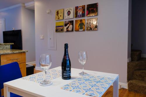 a bottle of wine sitting on a table with two glasses at Amazing ATL downtown houses - minutes walk to bars, food and transport! in Atlanta
