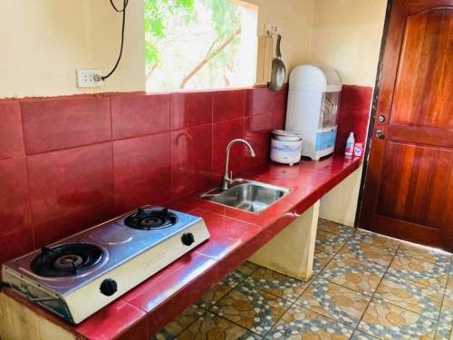 a kitchen counter with a stove and a sink at Jeremias Transient Patar Bolinao near WhiteBeach LightHouse in Bolinao