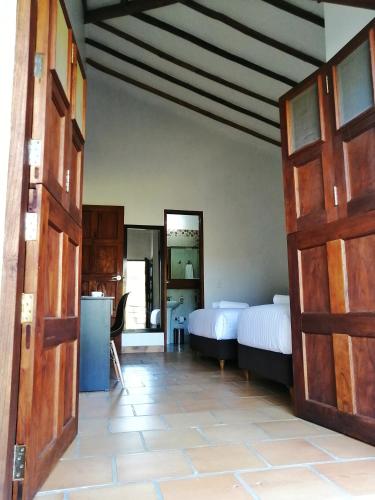 a room with two beds and a room with two doors at CASA LLANO HIGUERAS in Barichara