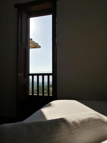 a bedroom with a bed and a window with a view at CASA LLANO HIGUERAS in Barichara