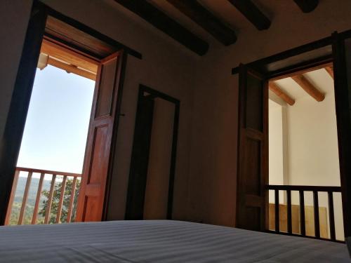 a bedroom with a bed and an open door at CASA LLANO HIGUERAS in Barichara