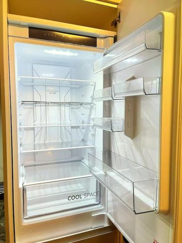 an empty refrigerator with its door open in a kitchen at Lovely 3 Bed Ground Floor Apartment Near QE Hospital Harborne Birmingham New in Birmingham