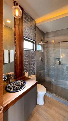 a bathroom with a toilet and a shower and a sink at Catrina Valle - Ubicación 10 in Valle de Guadalupe
