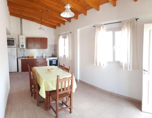 cocina y comedor con mesa y sillas en Cabañas Torres Del Sol en Santa María
