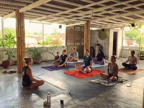 a group of people sitting in a yoga class at Tipsea Turtle Rooftop Hostel Gili Trawangan in Gili Trawangan